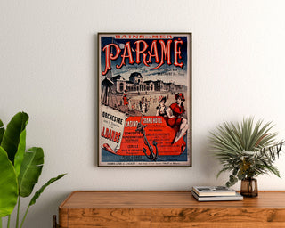 Vintage poster Bretagne – Paramé, baai van Saint-Malo, ingelijst boven een houten ladekast, tussen planten.