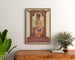 Historische poster – Koloniale tentoonstelling Semarang, 1914, ingelijst boven een houten dressoir tussen planten.