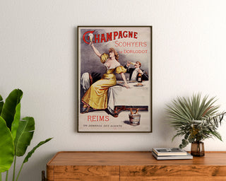 Vintage reclameposter Champagne Scohyers de Dorlodot, ingelijst boven een houten dressoir, tussen planten.