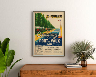Vintage toeristische affiche – Les Peupliers, camping van Pont-de-Vaux, ingelijst boven een houten dressoir, tussen planten.