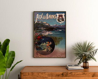 Vintage poster Aix‑les‑Bains, night festival, framed above a wooden dresser, flanked by plants.