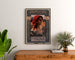 Vintageposter Amica, opera, ingelijst boven een houten dressoir, tussen planten.
