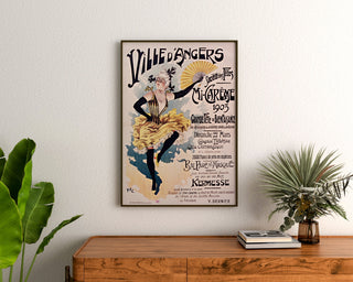 Vintage Angers Mid-Lent poster, framed above a wooden chest of drawers, between plants.