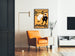 Vintageposter Dudley Hardy, comic guide, ingelijst in een woonkamer met een oranje fauteuil en een leeslamp.