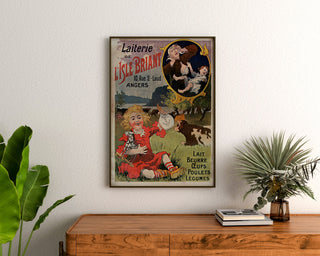 Vintage Laiterie de l’Isle Briant, Angers poster, framed above a wooden chest of drawers, between plants.